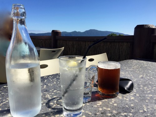 glass water and beer  on a table, in the sun